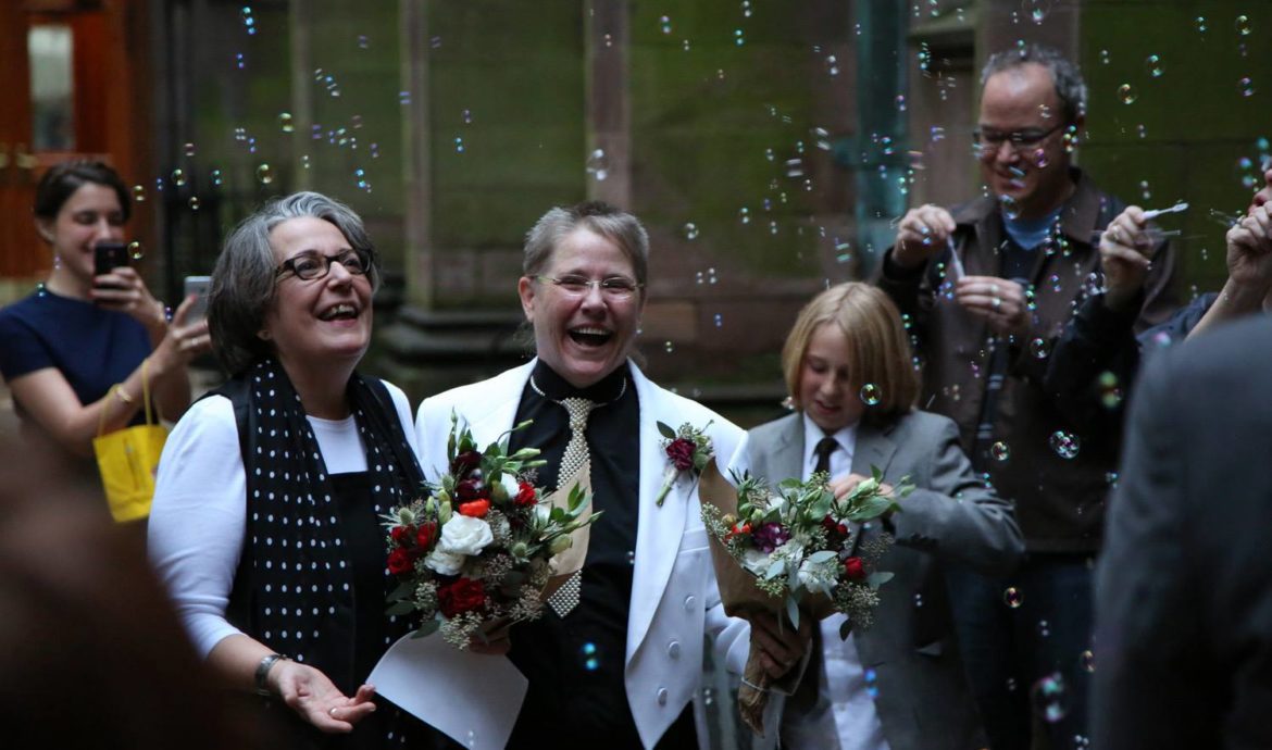 Amanda Hughes and Kirsten Wescott walking through bubbles after just getting married.